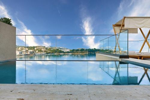 a swimming pool with a view of the water at Castello Infinity Suites - Adults Only in Agia Pelagia