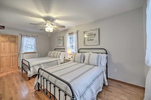 a bedroom with two beds and a ceiling fan at Lake Luzerne Home with Fire Pit on Hudson River in Lake Luzerne