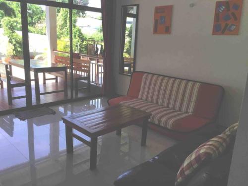 a living room with a couch and a table at Judith's 2 bedroom family home, sleeps 6 in Ko Samed