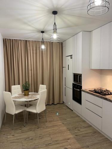 uma cozinha com uma mesa e cadeiras numa cozinha em V&G Apartment em Lviv