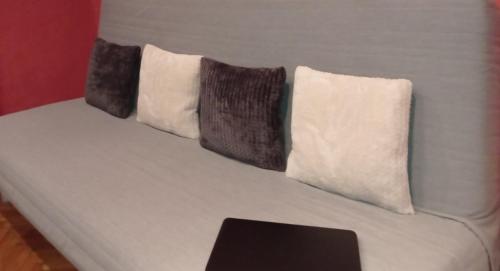 a white bed with three pillows on top of it at Studio Gizella in Budapest