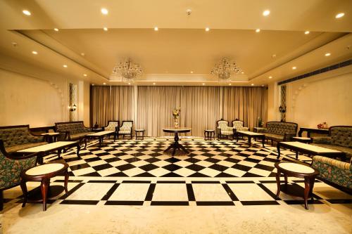 a waiting room with tables and chairs on a checkered floor at Sahdev Bagh in Pushkar