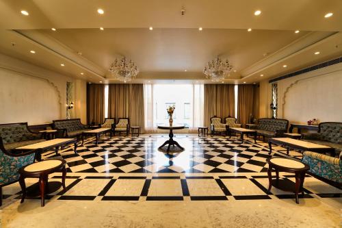 a lobby with chairs and tables on a checkered floor at Sahdev Bagh in Pushkar