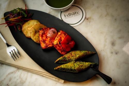 a black plate with food on a table at Sahdev Bagh in Pushkar