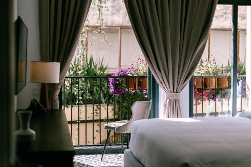 Un pat sau paturi într-o cameră la La Chronique Hotel