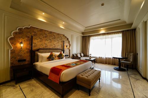 a hotel room with a large bed and a chair at Sahdev Bagh in Pushkar