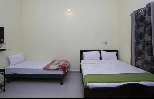 two beds sitting next to each other in a room at Coorg North Breeze Homestay in Madikeri