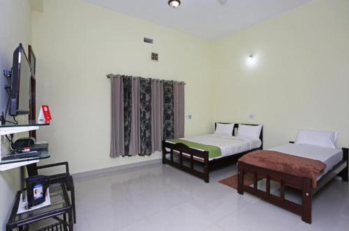 a room with two beds and a tv and a couch at Coorg North Breeze Homestay in Madikeri