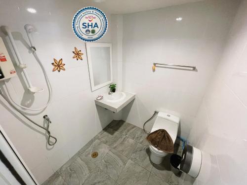 a white bathroom with a toilet and a sink at Naiyang Seaview Place Resort in Nai Yang Beach
