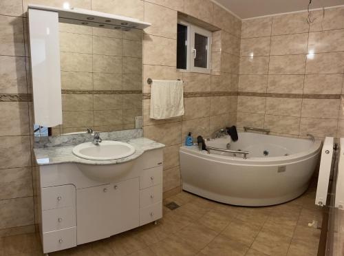 a bathroom with a tub and a sink at Pensiunea Novis in Novaci