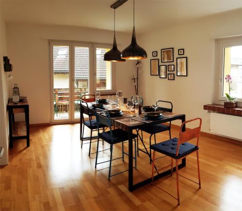 uma sala de jantar com uma mesa preta e cadeiras em Interlaken City Apartments em Interlaken