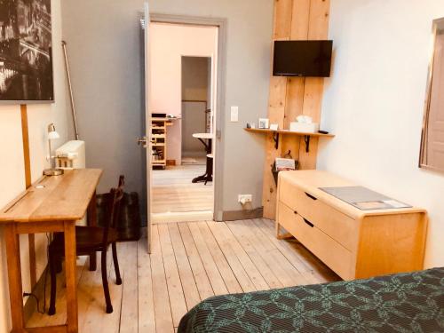 a room with a bedroom with a desk and a table at Chambre-studio Le 42 in Nogent-le-Rotrou