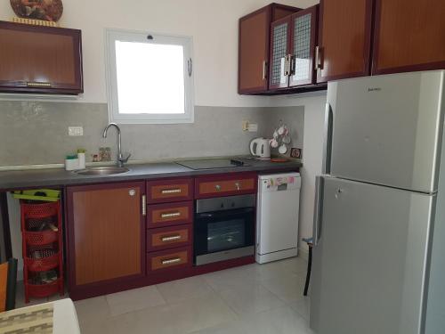 a kitchen with a white refrigerator and wooden cabinets at Hurghada Village sea view in Hurghada