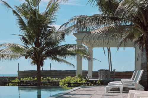 a resort with palm trees and a swimming pool at Naomi Beach Resort - Adults only in Weligama