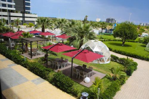 an overhead view of a restaurant with tables and red umbrellas at ADAM Hotel Suites in Tunis