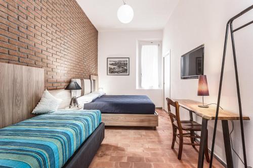 a bedroom with a bed and a desk with a television at Casa Gardenia -affittacamere in Gatteo