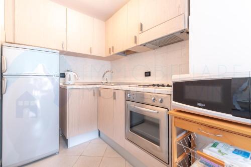 a kitchen with a refrigerator and a microwave at Bilocale in centro con terrazzo e wifi - AS11 in Breuil-Cervinia