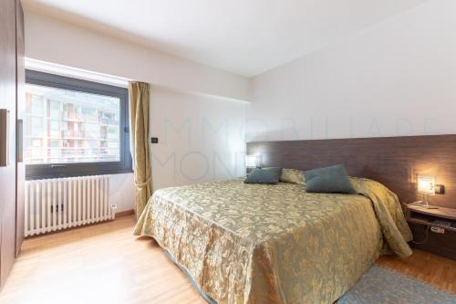 a bedroom with a bed and a large window at Bilocale in centro con terrazzo e wifi - AS11 in Breuil-Cervinia