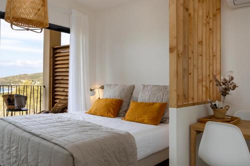 a bedroom with a bed with yellow pillows and a balcony at Casa Marina Cargèse in Cargèse