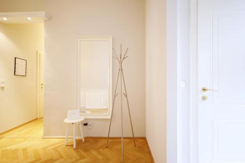 a tripod in a room with a mirror and a stool at HeyMi Apartments Karlsplatz in Vienna
