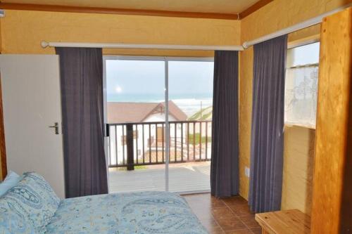 a bedroom with a large window with a view of the ocean at Old Ladder in Oyster Bay