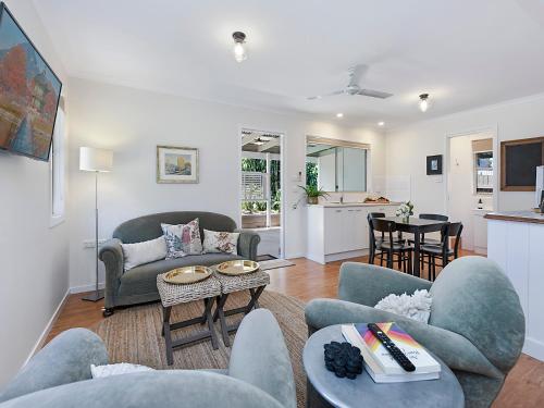 a living room with a couch and chairs and a table at Sweet Cottage, sleeps 4 - stroll to Maleny in Maleny