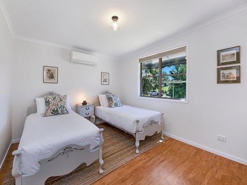 a bedroom with two beds and a window at Sweet Cottage, sleeps 4 - stroll to Maleny in Maleny