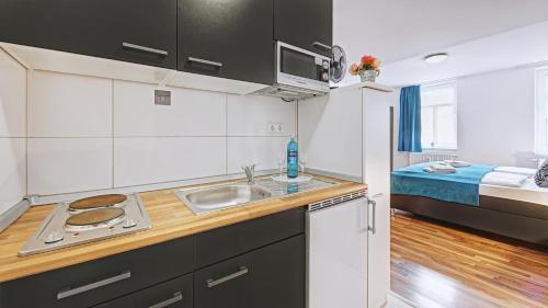a kitchen with a sink and a bed in a room at Boutique-Hotel Kronenstuben in Ludwigsburg