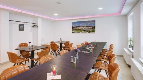 a room with tables and chairs and a painting on the wall at Boutique-Hotel Kronenstuben in Ludwigsburg