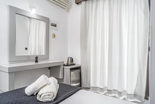 a bedroom with a bed with a sink and a mirror at Panorama in Laganas