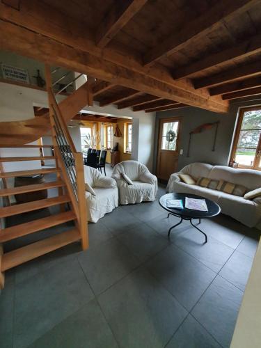 een woonkamer met een trap in een huis bij Au chemin du paradis Gîte de 10 personnes 4 Etoiles in Saint-Martin-lez-Tatinghem