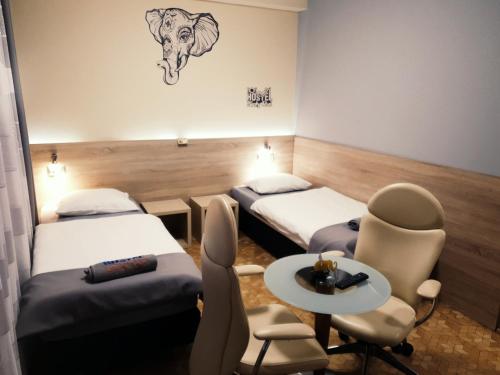 Pokój z 2 łóżkami, stołem i krzesłami w obiekcie Biały Słoń w mieście Gdynia