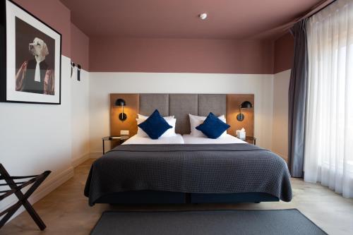 a bedroom with a large bed with blue pillows at The Barrister in Valletta