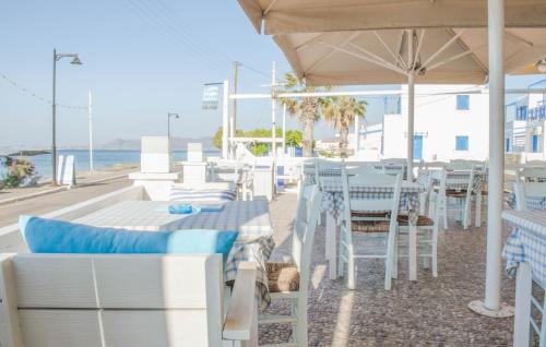 a restaurant with white tables and chairs and the ocean at Laza Beach in Skala