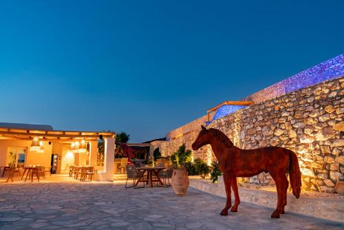a horse standing in front of a stone wall at Mythic Paros , Adults Only in Agia Irini Paros
