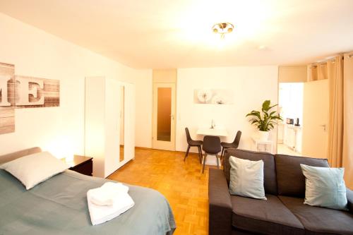 a living room with a couch and a table at Studio Apartment - zentral mit Parkplatz - Balkon in Bayreuth