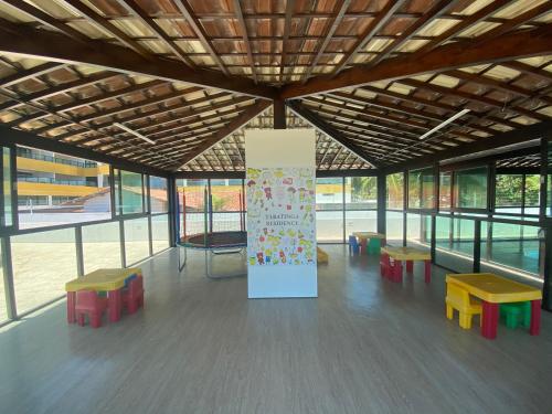 a room with benches and a sign in a building at Tabatinga Residence Flat Pé na Areia II in Conde