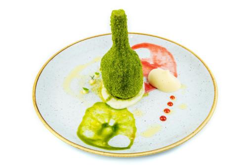 a plate of food with vegetables and a pickle at Relais Chiaramonte in Ragusa