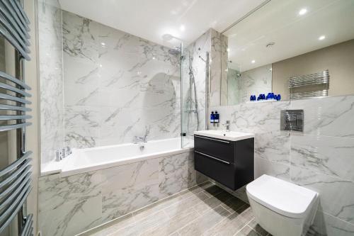 uma casa de banho com uma banheira, um WC e um lavatório. em The Pines - Stunning 3 Bedroomed Apartment, Gleneagles em Auchterarder