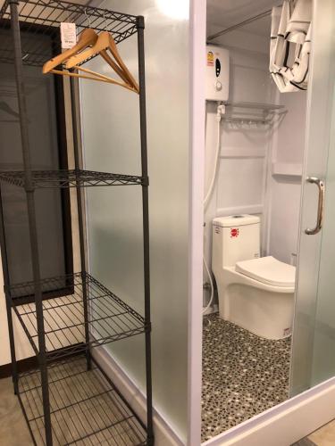 a bathroom with a toilet and a glass door at Bluefin Guesthouse in Bangkok