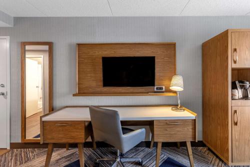 a desk with a chair and a television on a wall at Comfort Inn in Sarnia