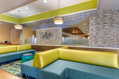 uma sala de espera com sofás amarelos e azuis em Comfort Inn & Suites Near Universal Orlando Resort-Convention Ctr em Orlando