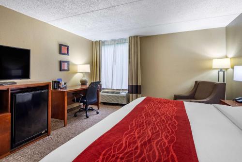 a hotel room with a bed and a desk and a tv at Comfort Inn Matthews / Charlotte in Matthews