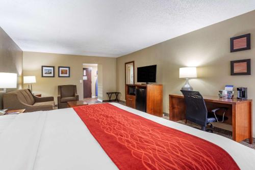 a hotel room with a large bed and a desk at Comfort Inn Matthews / Charlotte in Matthews