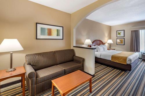 Habitación de hotel con cama y sofá en Comfort Suites Chesapeake - Norfolk, en Chesapeake