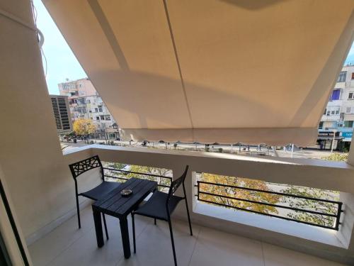 a balcony with two chairs and a table and a window at Arkle Apartment 1 in Tirana