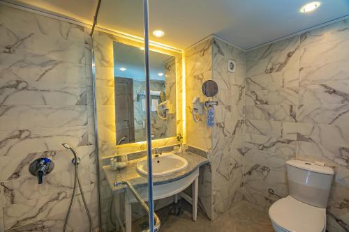 a bathroom with a sink and a toilet and a shower at Titanic Aqua Park Resort - Families and Couples only in Hurghada