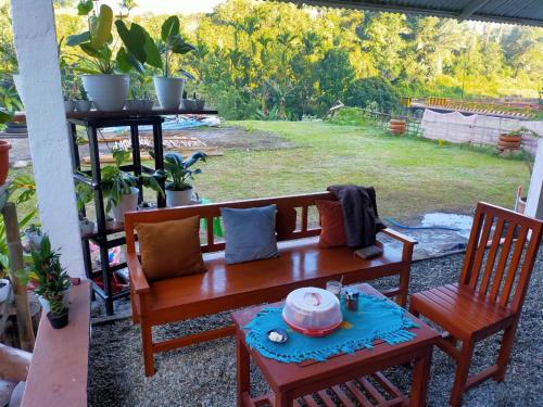 a bench and two chairs on a patio at Rago's Homestay in Kelimutu
