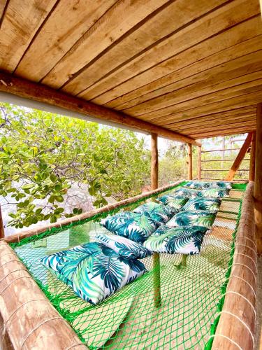 a row of green and blue pillows on a porch at Rock and Sea Resort in Watamu