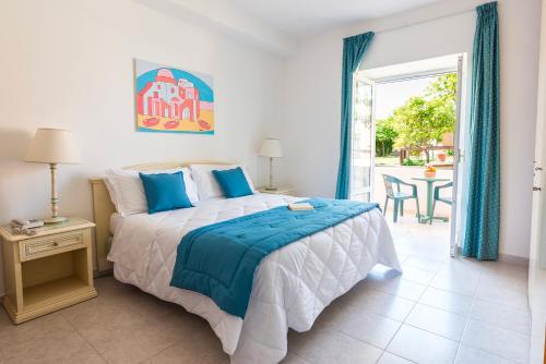 a bedroom with a bed and a patio with a table at Hotel Parco Delle Agavi in Ischia
